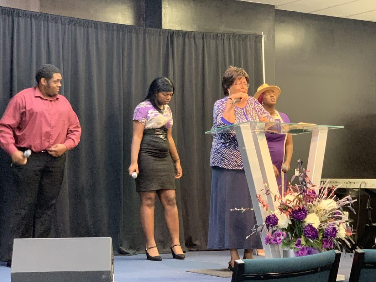 Church members sharing testimonies on stage