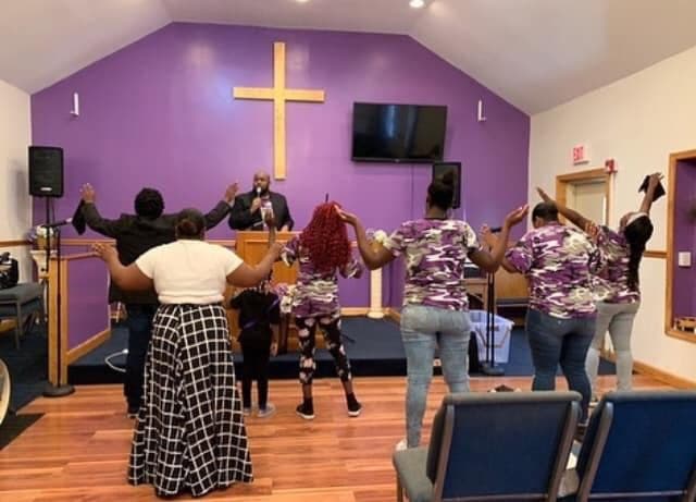 A small group with hands raised in worship