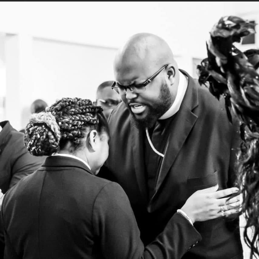 Pastor Charles warmly greeting a guest